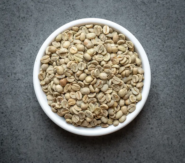 Colombia conventional green coffee beans in a white bowl