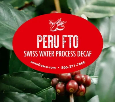 Peru FTO Swiss Water Process Decaf label over ripe red coffee cherries and green leaves