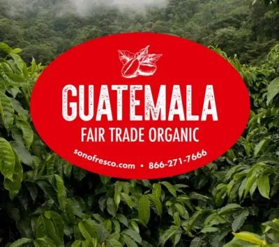 Guatemala Fair Trade Organic coffee label over green coffee plants in the highlands