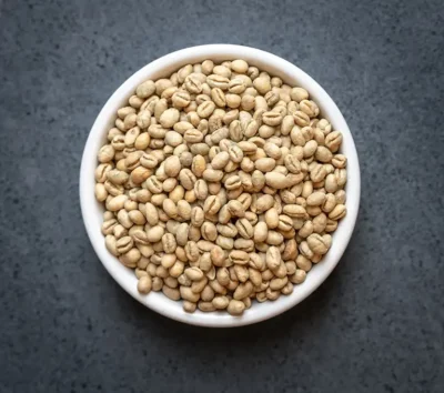 Tanzania Peaberry green coffee beans in a bowl on a dark tabletop
